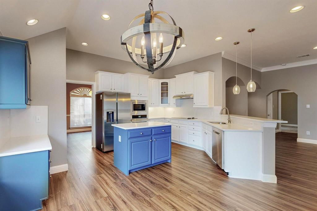 a kitchen with stainless steel appliances granite countertop a stove oven and a wooden floors