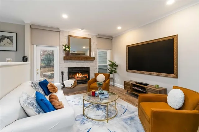 a living room with furniture and a flat screen tv with wooden floor