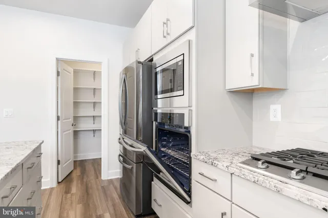 a kitchen with granite countertop a stove and a refrigerator