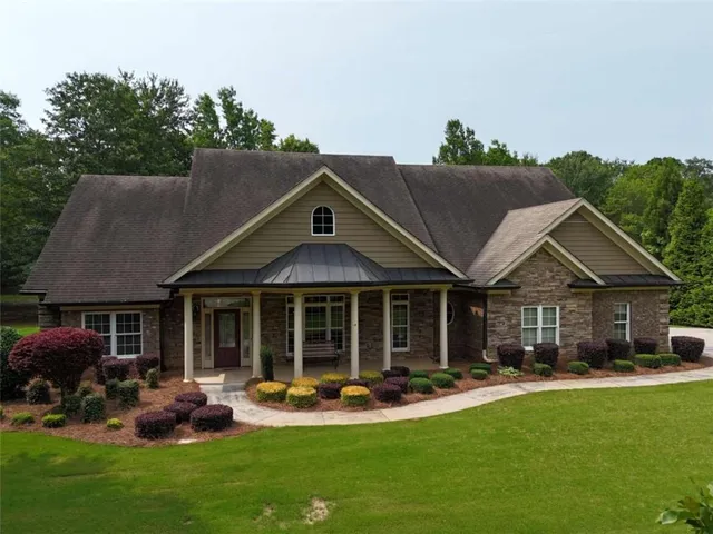 a front view of a house with garden and patio