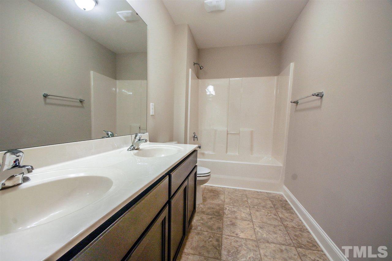 1216 Silver Farm Road Raleigh, NC 27603 - Photo 17 of 25 a bathroom with a sink a mirror and a bathtub