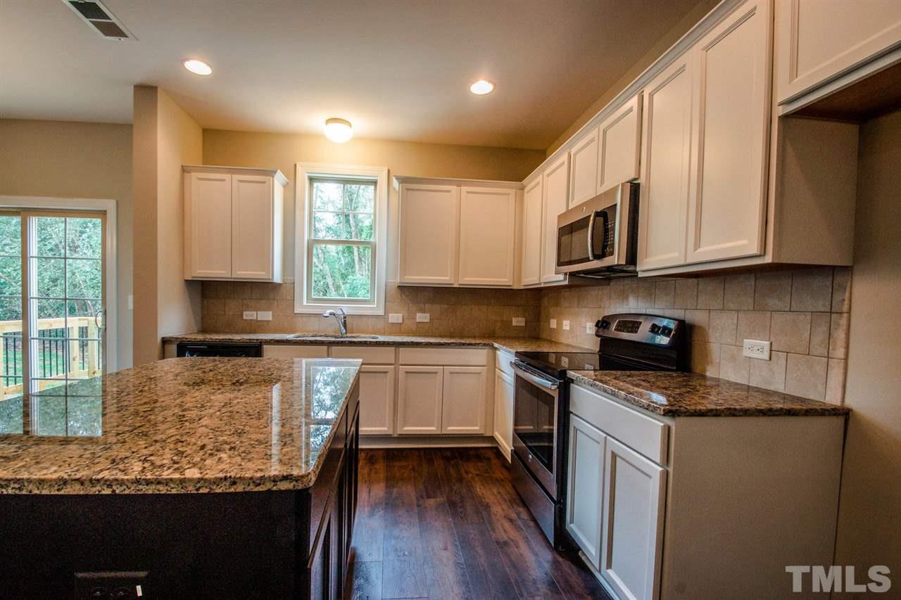 1216 Silver Farm Road Raleigh, NC 27603 - Photo 4 of 25 a kitchen with granite countertop cabinets stainless steel appliances a sink and a window