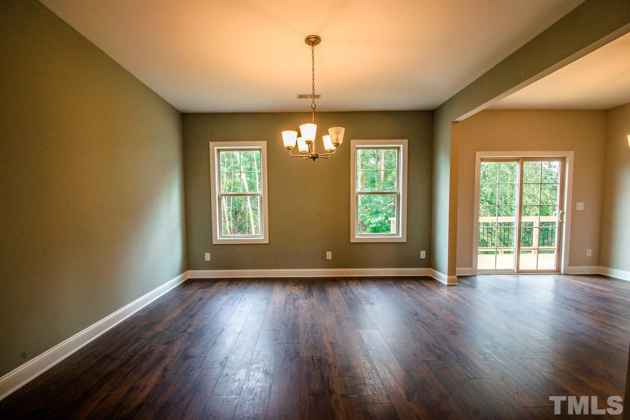 1216 Silver Farm Road Raleigh, NC 27603 - Photo 5 of 25 a view of an empty room with wooden floor and a window