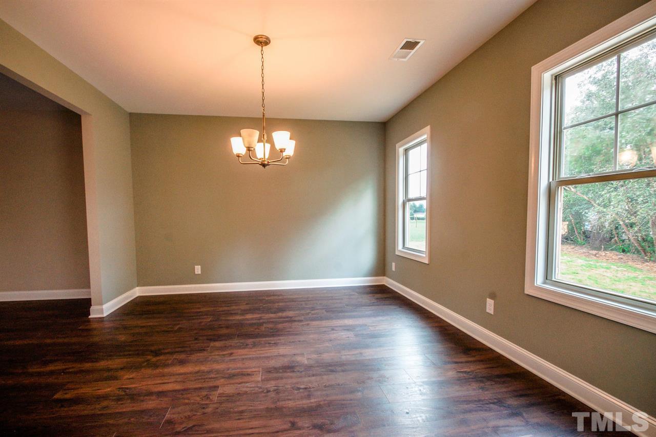 1216 Silver Farm Road Raleigh, NC 27603 - Photo 6 of 25 a view of an empty room with wooden floor and a window