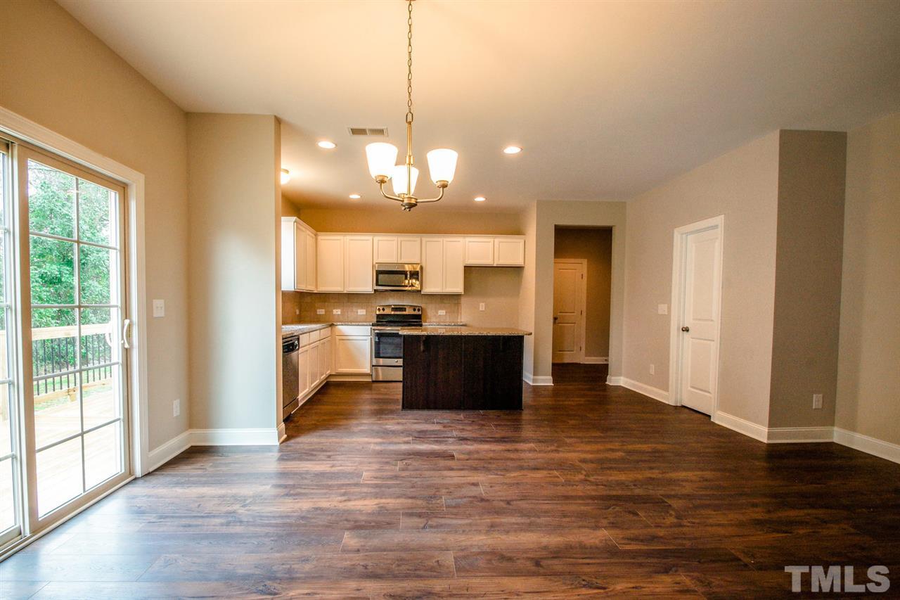 1216 Silver Farm Road Raleigh, NC 27603 - Photo 7 of 25 a view of a kitchen with kitchen island wooden floor stainless steel appliances and cabinets