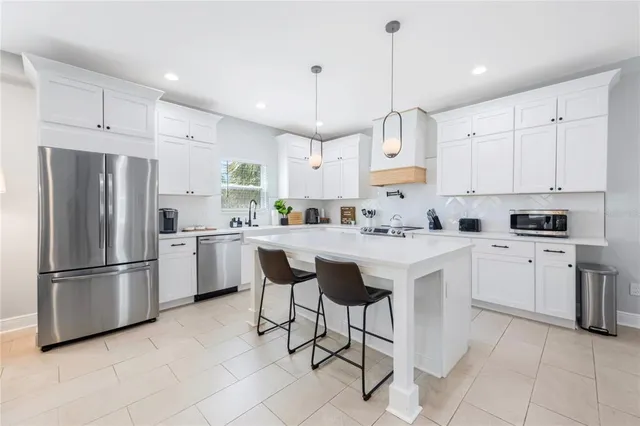 a living room with furniture kitchen view and a window