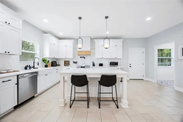 a kitchen with stainless steel appliances a stove microwave and a refrigerator