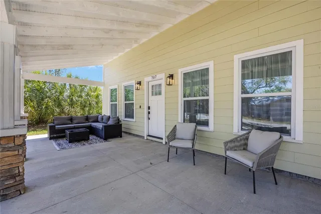 a kitchen with stainless steel appliances granite countertop a sink a stove a refrigerator and white cabinets with wooden floor