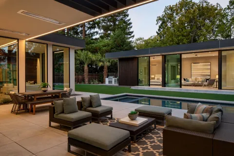 a roof deck with couches and potted plants