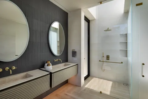 a bathroom with a double vanity sink and a mirror