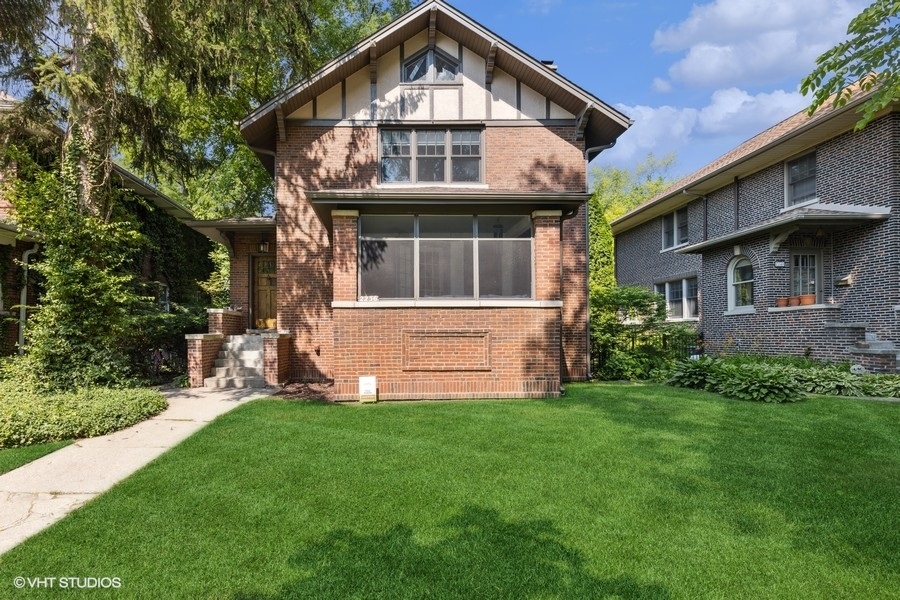 a front view of a house with a yard and trees