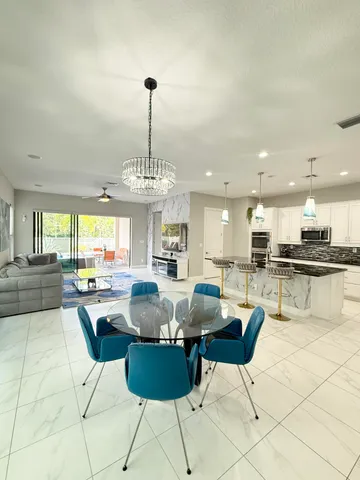 a kitchen with stainless steel appliances kitchen island granite countertop a table and chairs in it