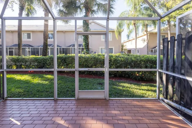 a view of backyard with wooden fence and two windows
