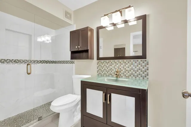 a bathroom with a sink toilet and shower