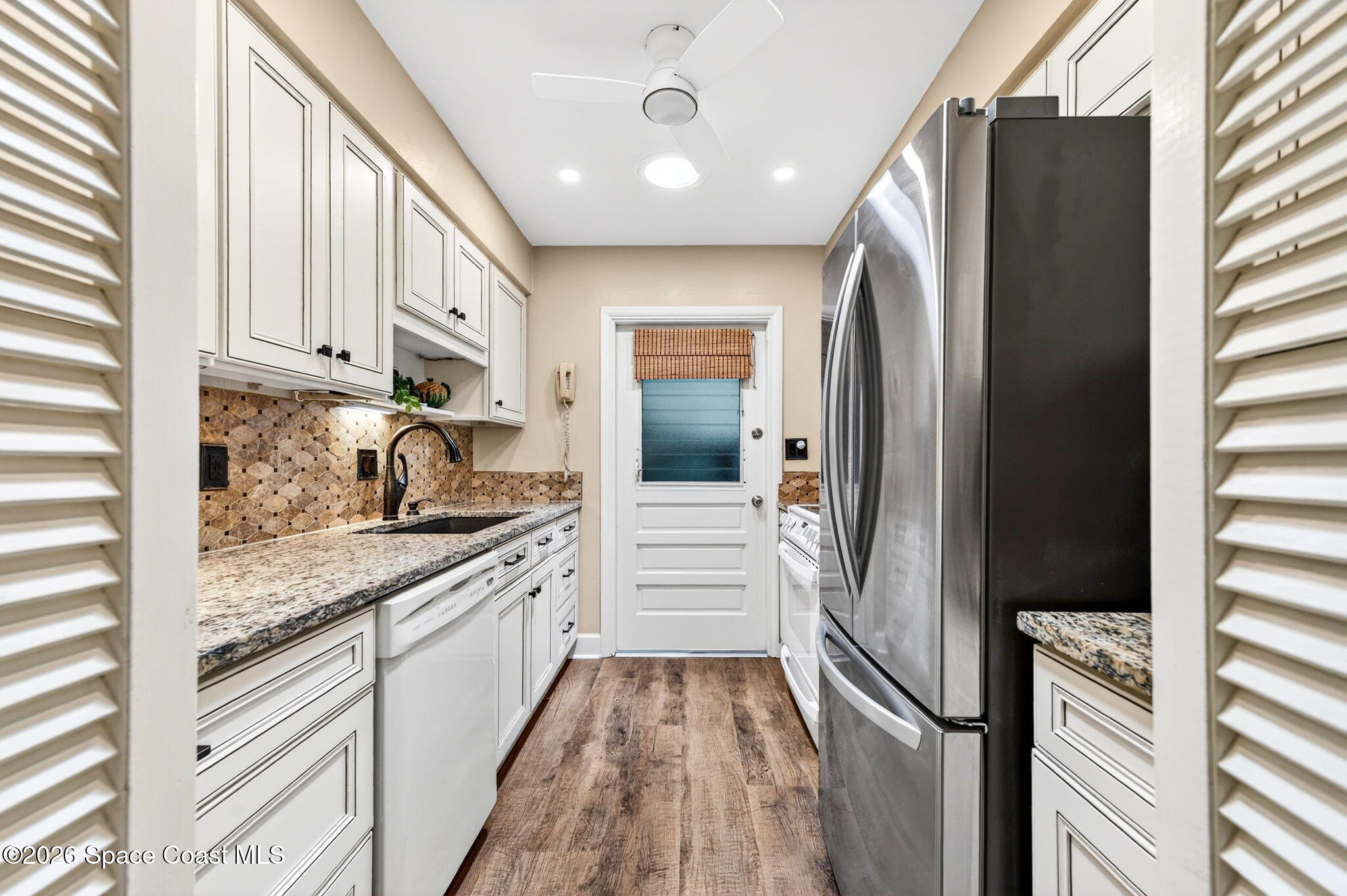 935 Samar Road Cocoa Beach, FL 32931 - Photo 8 of 22 a kitchen with granite countertop a refrigerator and a sink