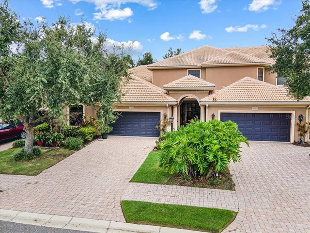 a front view of a house with a yard and potted plants