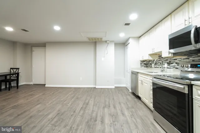 a view of kitchen with microwave stove and cabinets