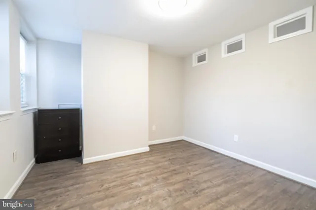 an empty room with wooden floor and cabinet