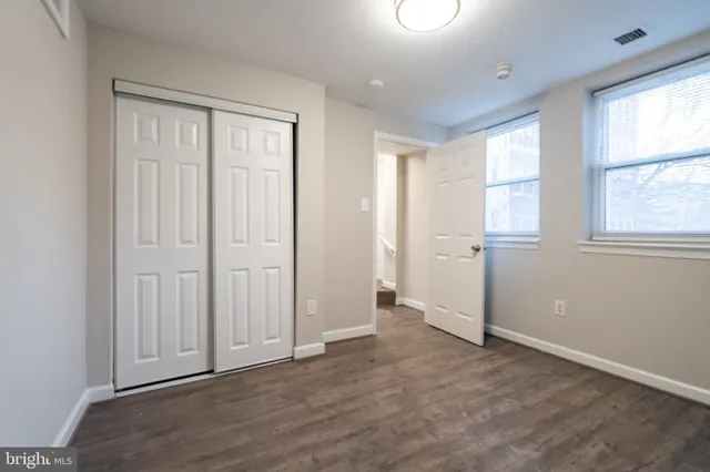 an empty room with windows and closet