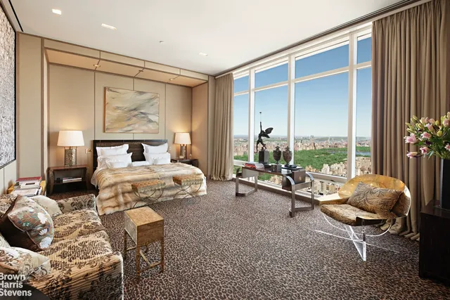 a bedroom with furniture and a large window