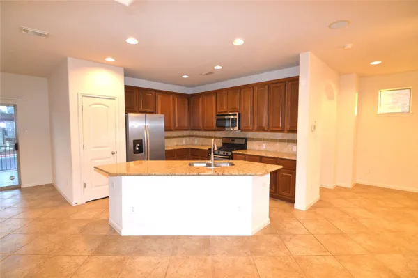 a view of a kitchen with a sink and a refrigerator