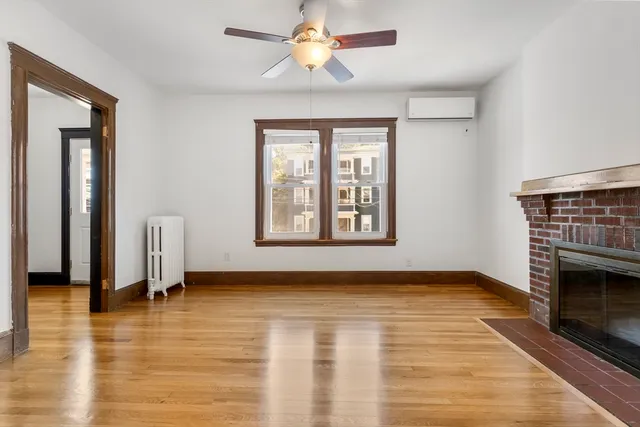 wooden floor fireplace and windows in an empty room