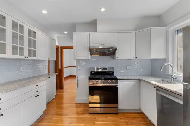 a kitchen with kitchen island granite countertop a sink cabinets and stainless steel appliances