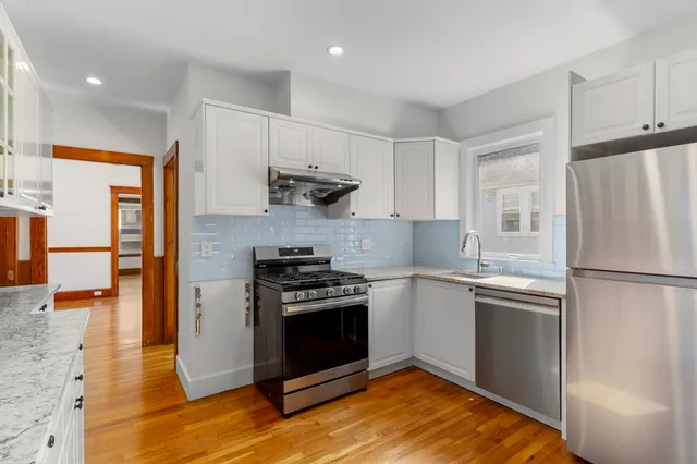 a kitchen with stainless steel appliances granite countertop a stove a refrigerator and a refrigerator