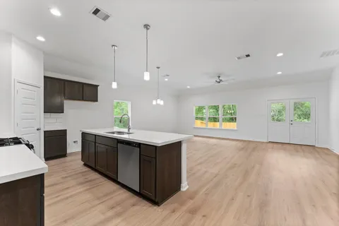 a kitchen with stainless steel appliances granite countertop a sink a stove and a wooden floors