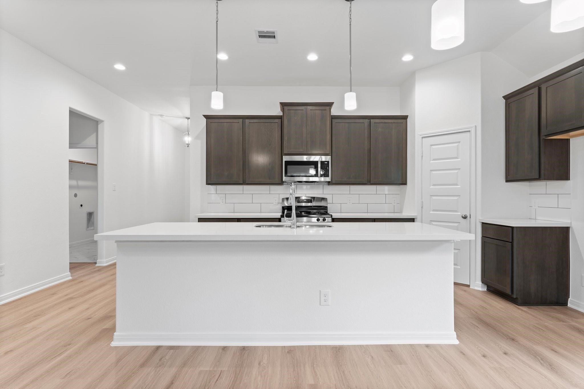12011 Noble Heart Drive Willis, TX 77318 - Photo 17 of 35 a large kitchen with a large counter top a sink stainless steel appliances and cabinets