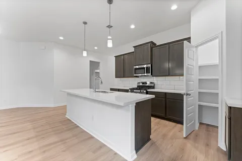 a kitchen with kitchen island a sink stainless steel appliances and cabinets