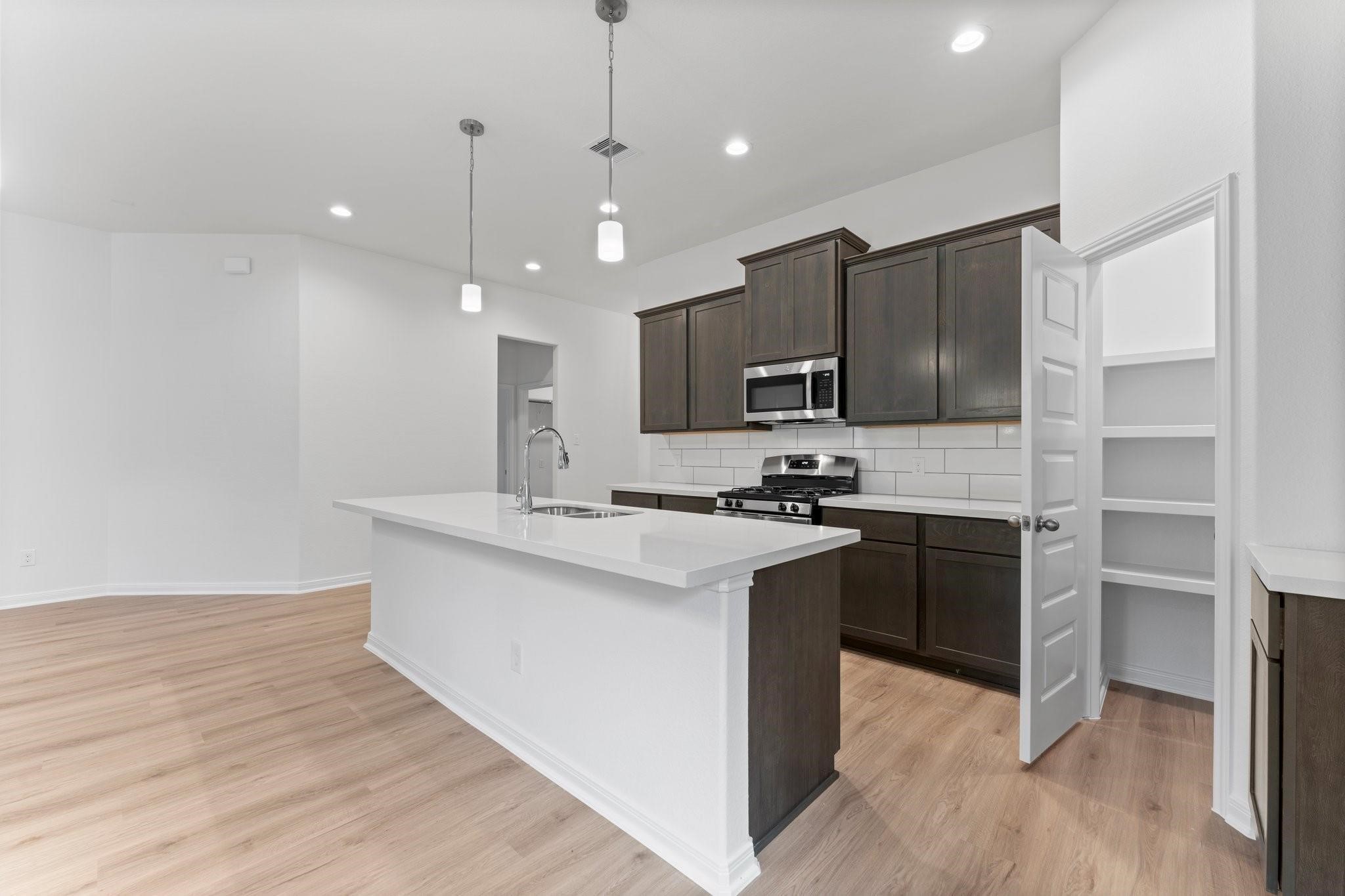 12011 Noble Heart Drive Willis, TX 77318 - Photo 18 of 35 a kitchen with kitchen island a sink stainless steel appliances and cabinets