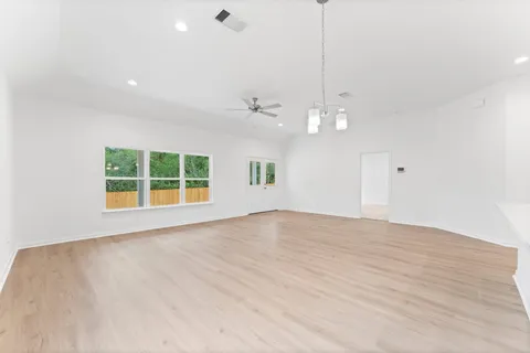 a view of an empty room with a window and cabinets