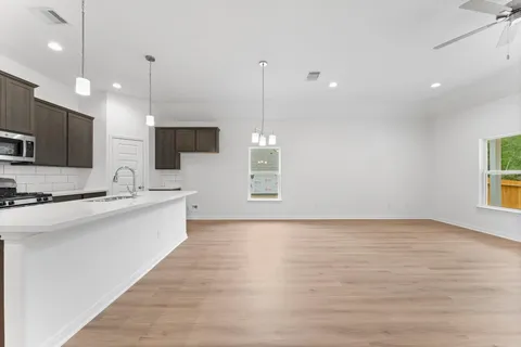 a large kitchen with kitchen island a sink stainless steel appliances and a chandelier