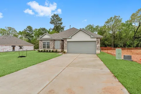 a front view of a house with a yard and trees