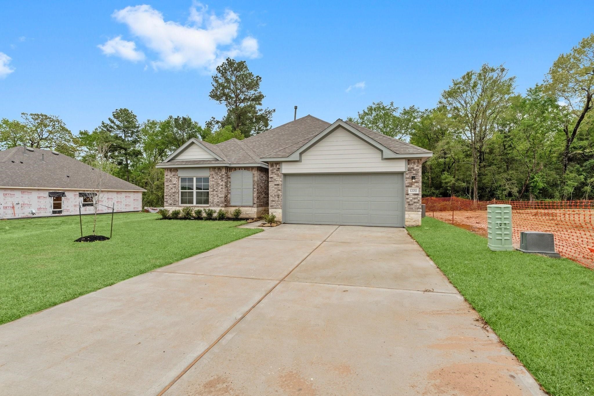 12011 Noble Heart Drive Willis, TX 77318 - Photo 2 of 35 a front view of a house with a yard and trees