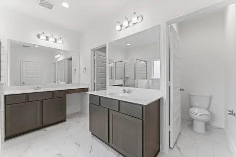 a bathroom with a double vanity sink mirror and toilet