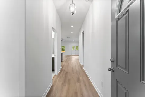 a view of a hallway with wooden floor