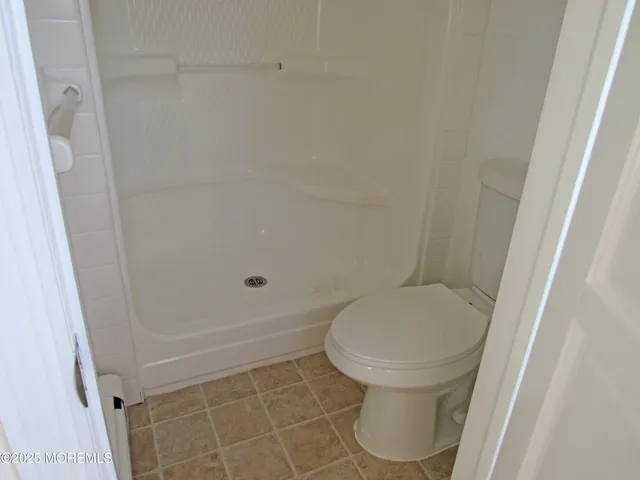 a bathroom with a toilet and a shower