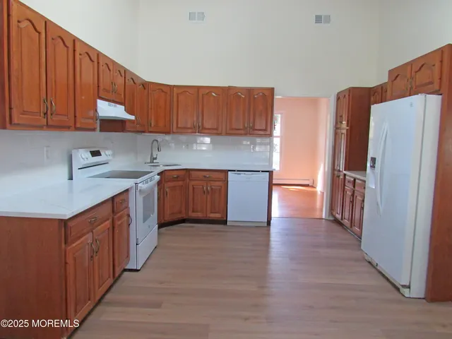 a kitchen with stainless steel appliances granite countertop a refrigerator a sink and a stove