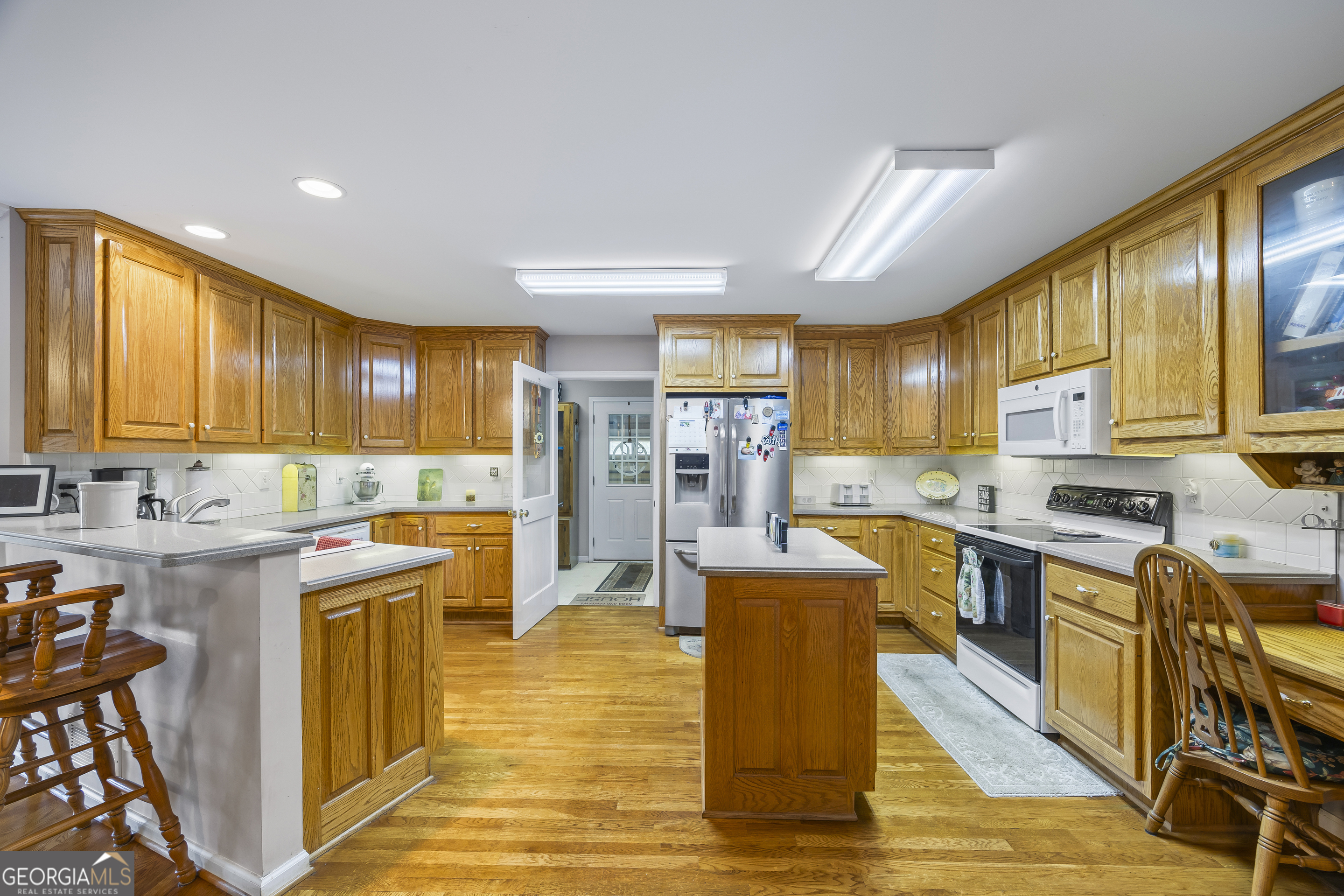1112 Reno Road Royston, GA 30662 - Photo 39 of 74 a kitchen with stainless steel appliances granite countertop a stove top oven a sink dishwasher a dining table and chairs with wooden floor