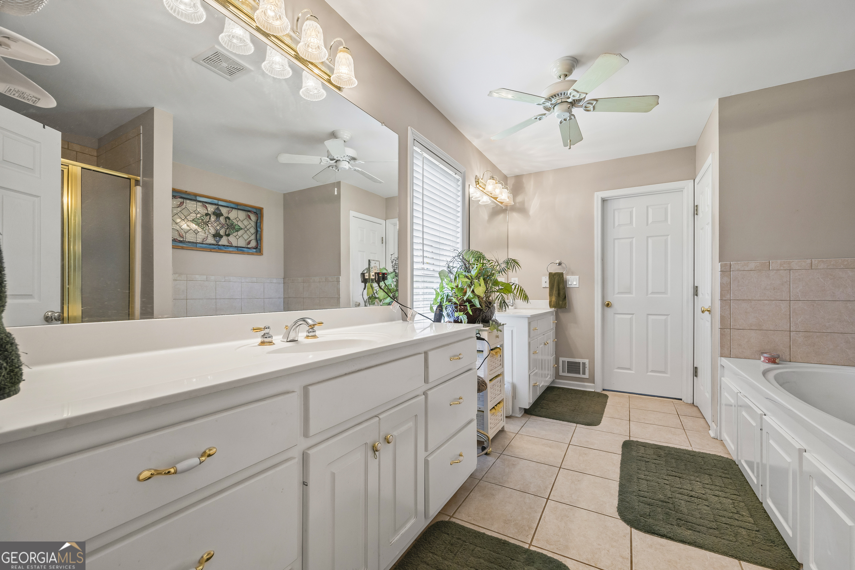 1112 Reno Road Royston, GA 30662 - Photo 60 of 74 a spacious bathroom with a double vanity sink a mirror a bathtub and a shower