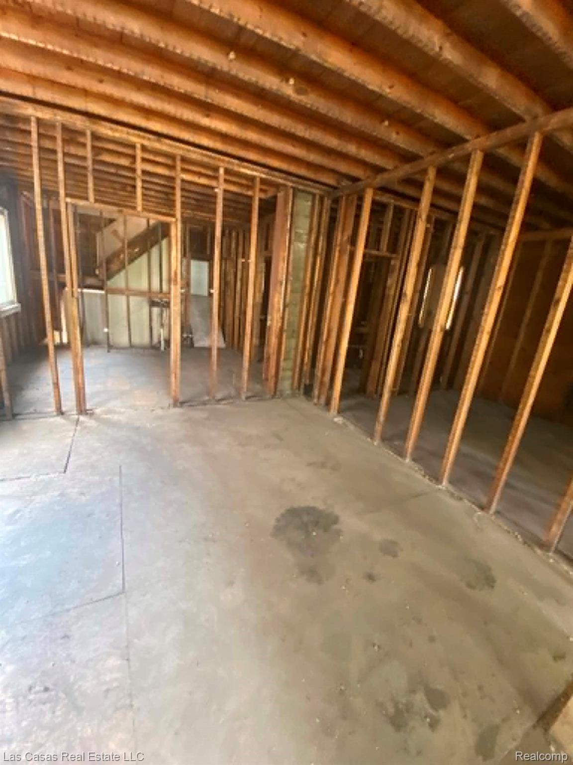 7545 Holmes Street Detroit, MI 48210 - Photo 4 of 12 Exposed wood framing defining interior spaces with visible ceiling joists and a concrete subfloor