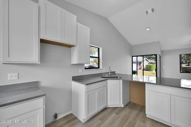 a kitchen with granite countertop white cabinets and white appliances
