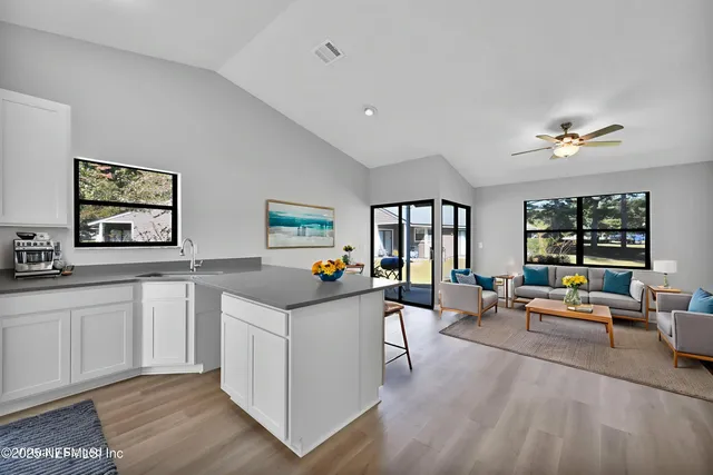 a very nice looking living room with a large window and wooden floor