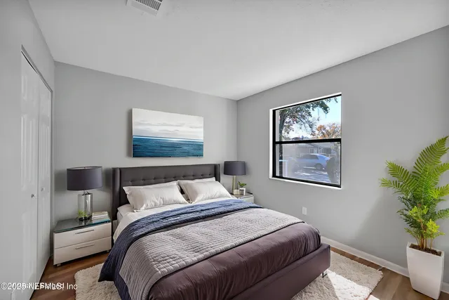 a bedroom with a bed and a painting on the wall