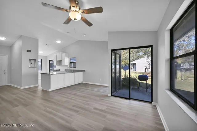 a view of kitchen with granite countertop cabinets and refrigerator
