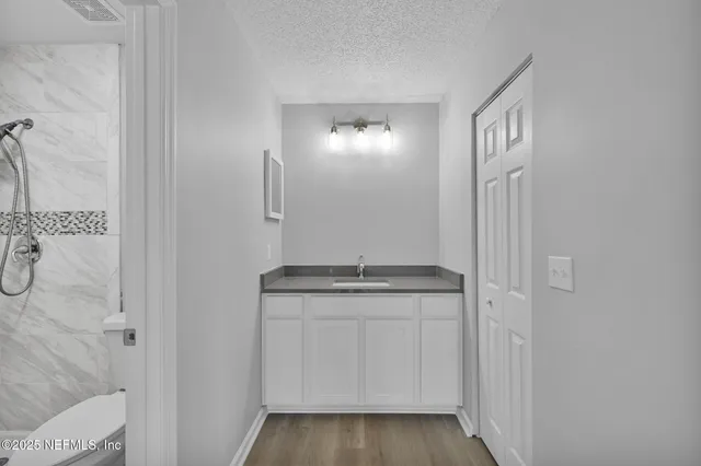 a bathroom with a granite countertop sink and a mirror