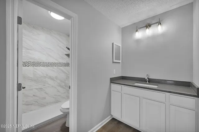 a bathroom with a granite countertop sink and mirror