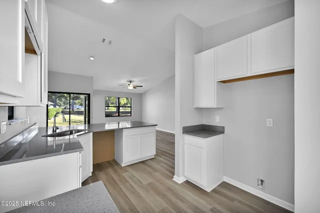 a kitchen with cabinets and wooden floor